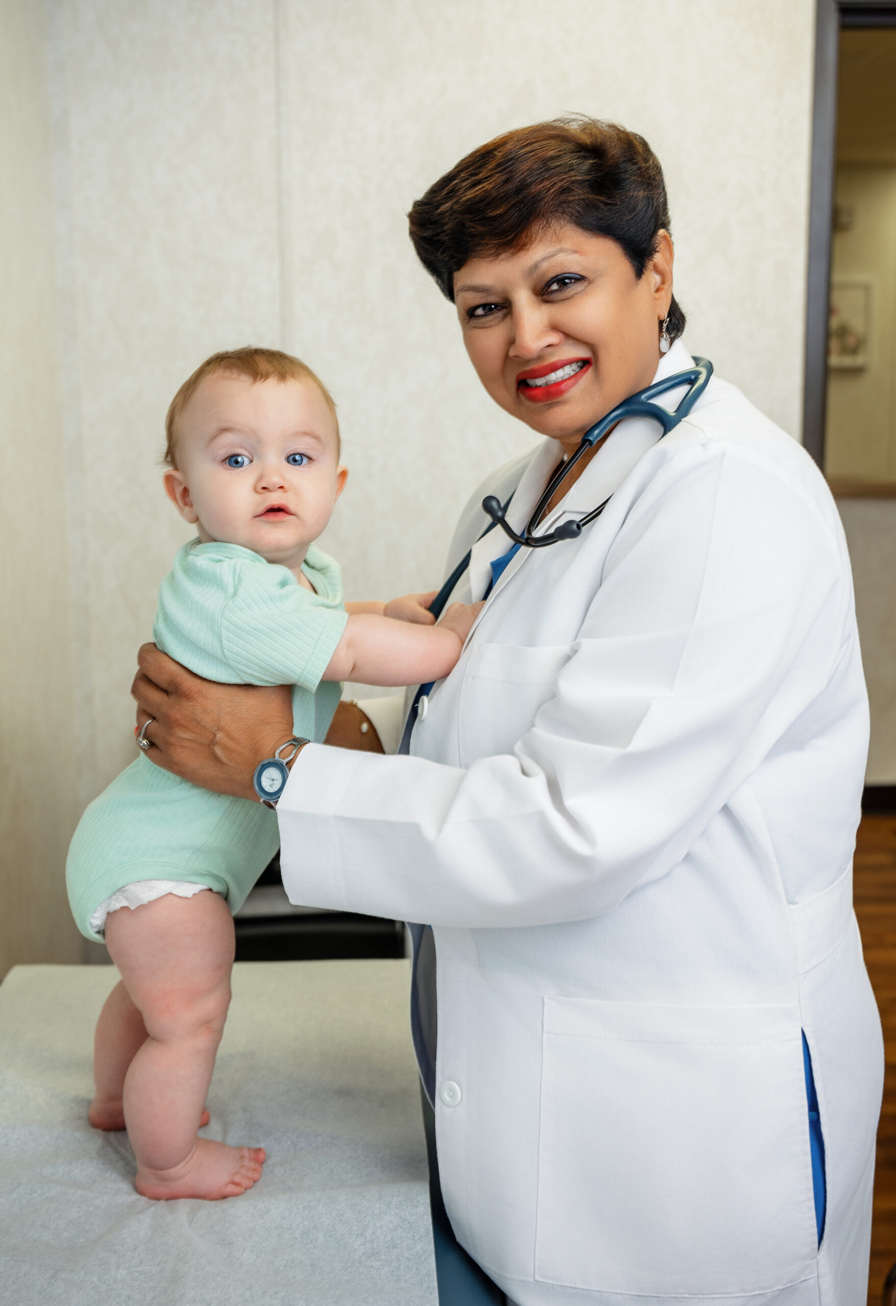 Dr. Chandra with baby looking at camera