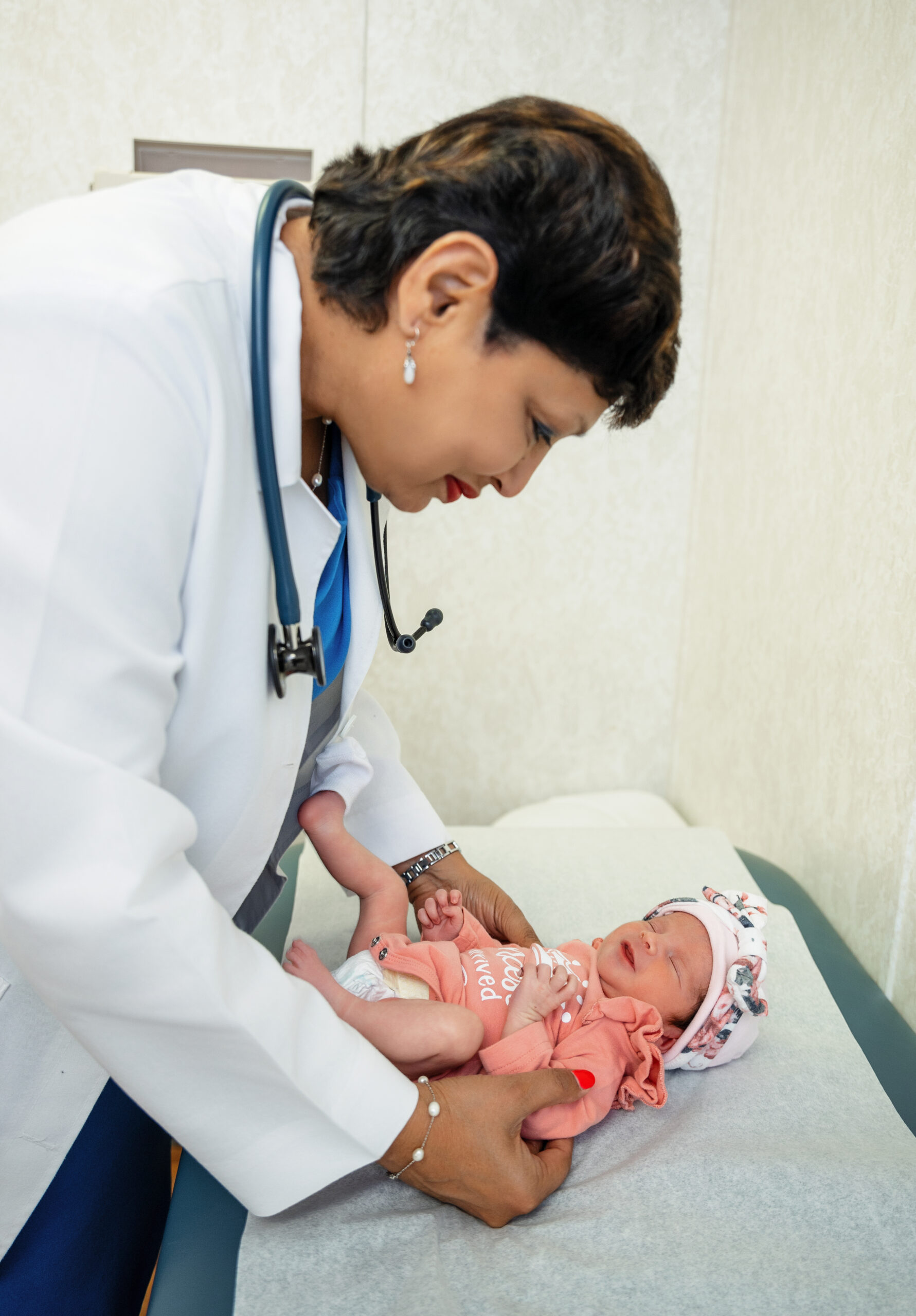 Dr. Chandra with newborn on exam table